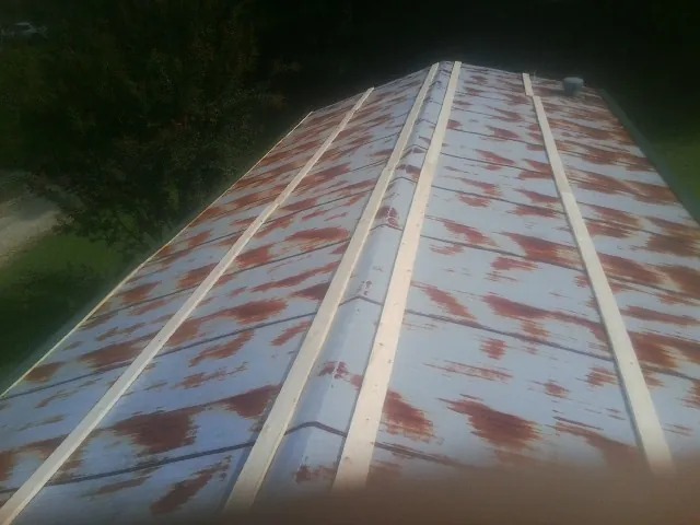 Rusted metal roof panels with new wood purlins before replacement — Storm Damage Roof Repair in Lignum by Roofing Brothers