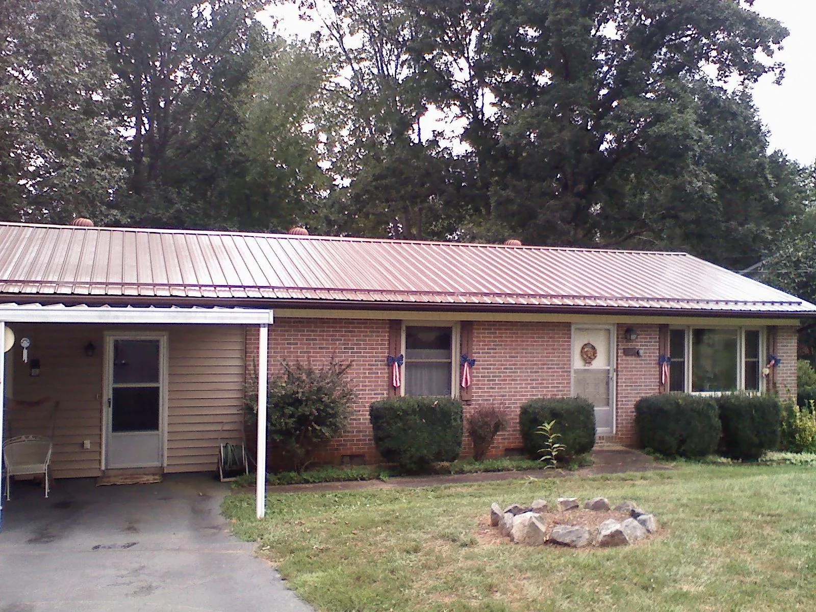 Bronze metal roof and carport on a brick ranch home — Roof Repair work by our crew in Lignum